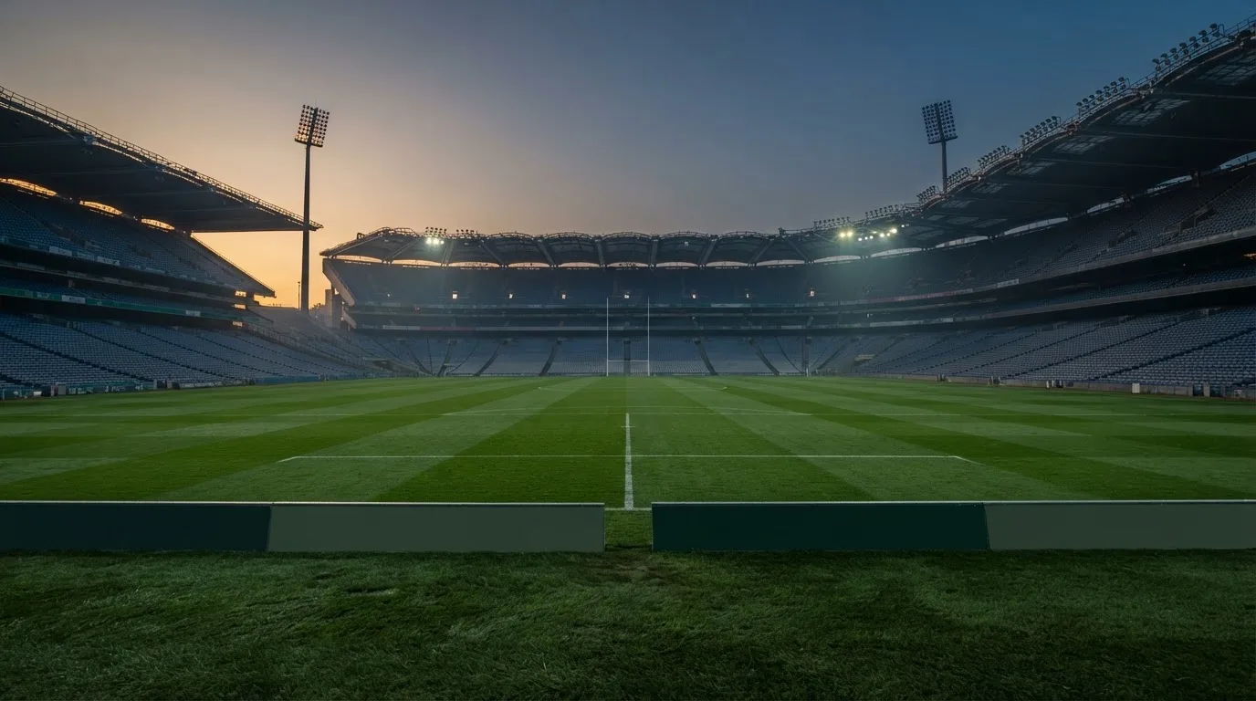 An empty football stadium with floodlight masts at dusk