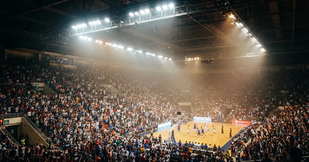 A packed sports hall under floodlights photographed from a long way off