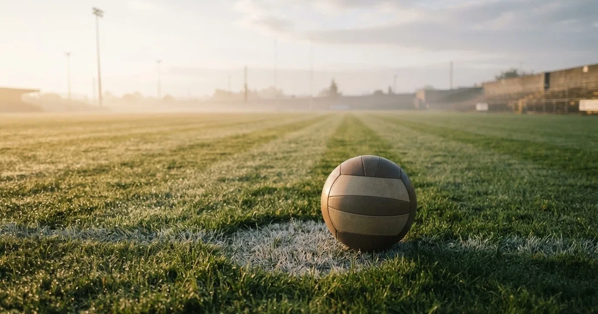 A ball on the centre spot of a grass pitch in morning light