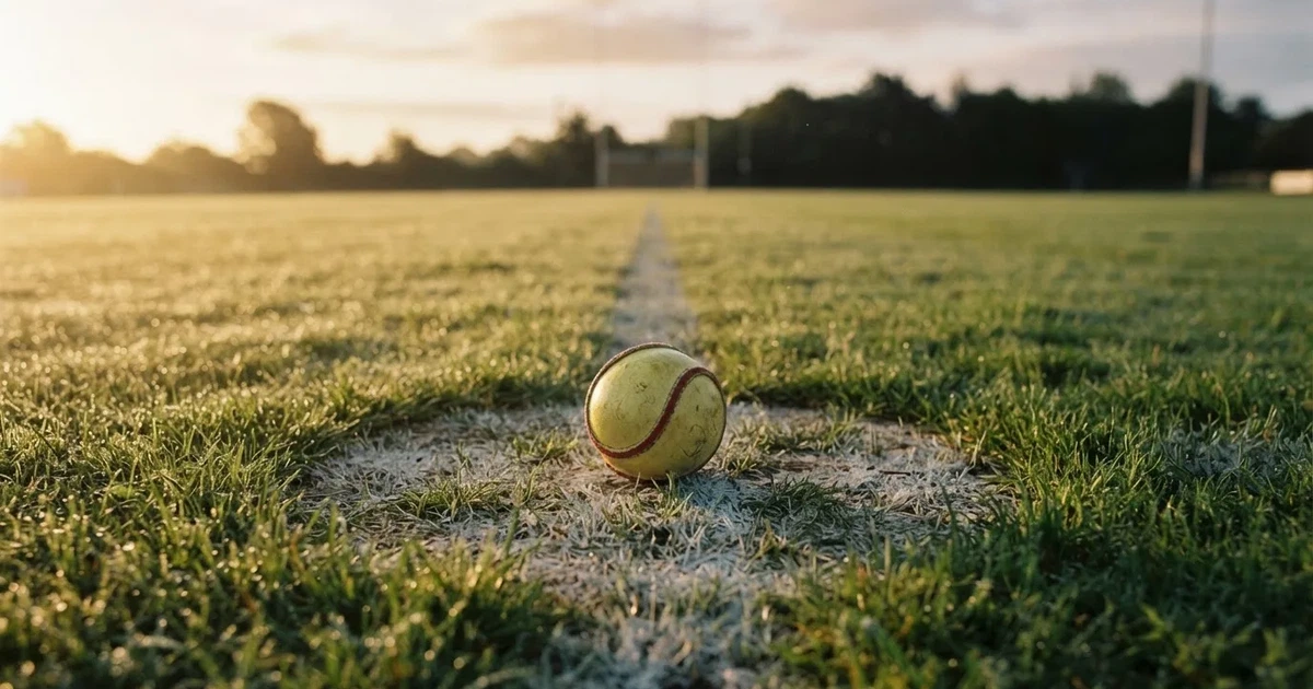A ball on the centre spot of a grass pitch in morning light
