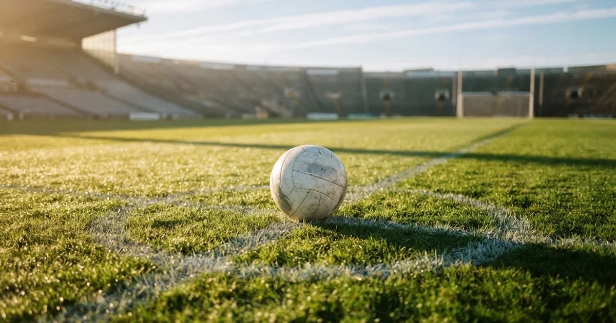 A ball on the centre spot of a grass pitch in morning light